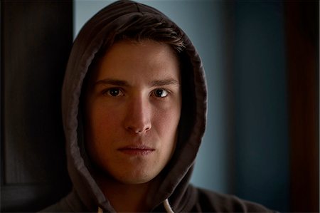 Portrait of intimidating young man wearing hood in shadows Foto de stock - Sin royalties Premium, Código: 614-08148709