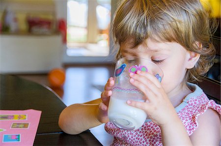 simsearch:614-08873965,k - Cute young girl drinking glass of milk at kitchen table Foto de stock - Sin royalties Premium, Código: 614-08148703