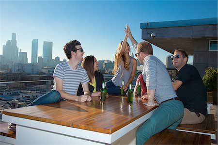 simsearch:614-06169404,k - Six adult friends drinking beer at table of rooftop bar with Los Angeles skyline, USA Foto de stock - Sin royalties Premium, Código: 614-08201997