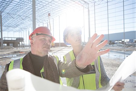 Architect explaining to builder on construction site Stock Photo - Premium Royalty-Free, Code: 614-08202145