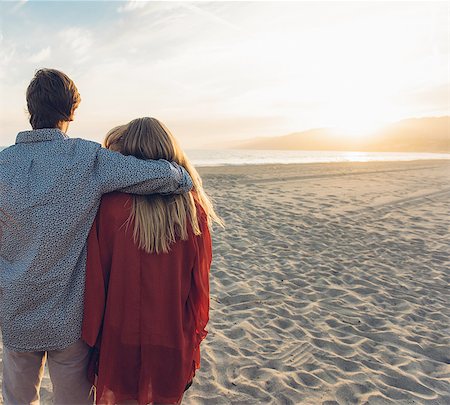 simsearch:614-08202219,k - Young couple standing on beach, hugging, rear view Fotografie stock - Premium Royalty-Free, Codice: 614-08202229