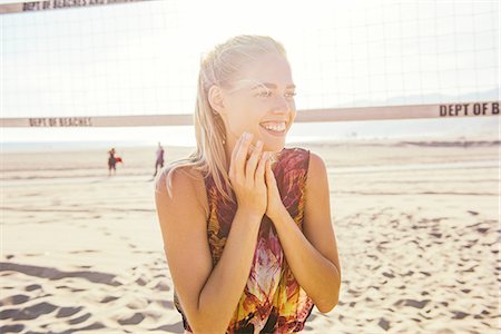 summer day - Young woman standing on beach by volleyball net, laughing Stock Photo - Premium Royalty-Free, Code: 614-08202237