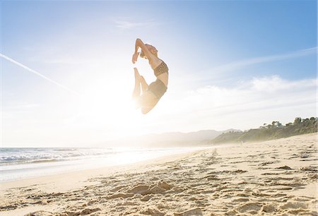 simsearch:614-08392515,k - Young woman on beach, leaping in air, sunset Stock Photo - Premium Royalty-Free, Code: 614-08202262