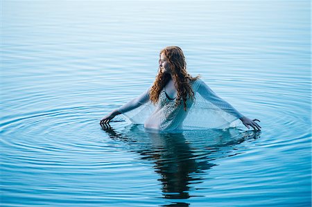 simsearch:614-08487979,k - Young woman standing in blue lake rippling surface with her fingers Stock Photo - Premium Royalty-Free, Code: 614-08202297