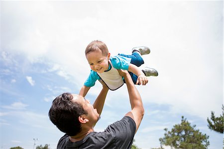 simsearch:649-08307462,k - Young man playing lifting up toddler brother in park Fotografie stock - Premium Royalty-Free, Codice: 614-08202325