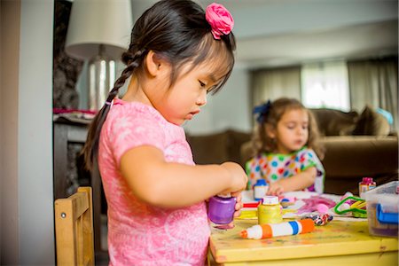 playdate - Two young girls sitting at table, making art, using paint Stock Photo - Premium Royalty-Free, Code: 614-08219823