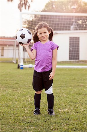 simsearch:614-08219838,k - Portrait of girl football player holding up football on practice pitch Foto de stock - Sin royalties Premium, Código: 614-08219845