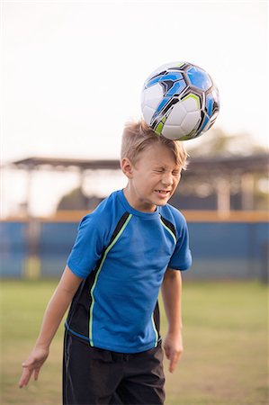 simsearch:614-08219838,k - Boy with eyes closed heading football on practice pitch Stock Photo - Premium Royalty-Free, Code: 614-08219848