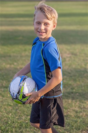 simsearch:614-08219838,k - Portrait of boy football player holding football on practice pitch Photographie de stock - Premium Libres de Droits, Code: 614-08219849