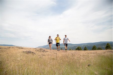 Small group of friends hiking through field Stock Photo - Premium Royalty-Free, Code: 614-08219872