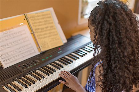 simsearch:640-03257223,k - Over shoulder view of girl playing keyboard Photographie de stock - Premium Libres de Droits, Code: 614-08219924