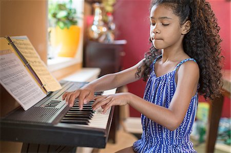 simsearch:640-03257223,k - Girl sitting playing keyboard, looking down Photographie de stock - Premium Libres de Droits, Code: 614-08219925