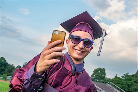 Graduate taking selfie with smartphone Photographie de stock - Premium Libres de Droits, Code: 614-08219998