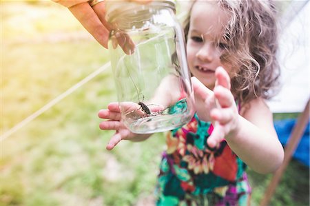 Grandfathers hand holding insect in jar for granddaughter Stock Photo - Premium Royalty-Free, Code: 614-08270014
