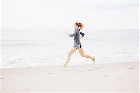 simsearch:614-08270048,k - Mid adult woman running along beach Photographie de stock - Premium Libres de Droits, Code: 614-08270049