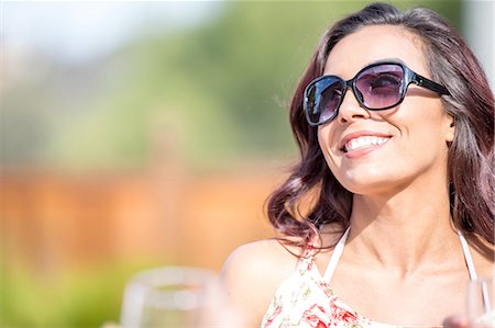 sunglasses women - Portrait of happy young woman wearing sunglasses in garden Stock Photo - Premium Royalty-Free, Code: 614-08270117