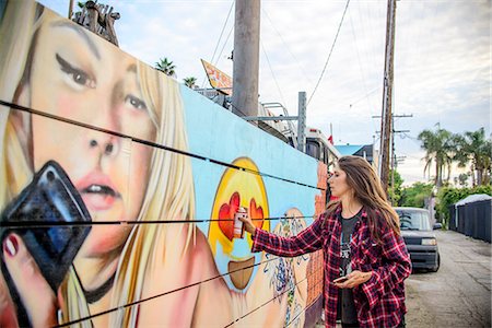 Graffiti artist spray painting wall on street, Venice Beach, California, USA Foto de stock - Royalty Free Premium, Número: 614-08270153