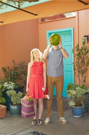 Woman with bottle of wine and man covering face with watermelon Stock Photo - Premium Royalty-Free, Code: 614-08270192