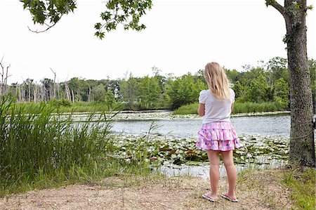 Rear of girl looking out over rural lake Stock Photo - Premium Royalty-Free, Code: 614-08270205