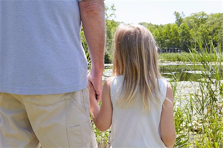 family with back looking out - Rear view of girl and grandfather holding hands by rural lake Stock Photo - Premium Royalty-Free, Code: 614-08270209
