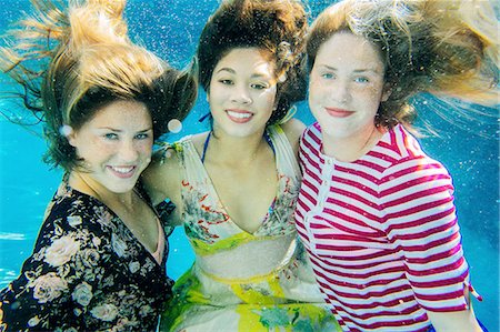 Portrait of three female swimmers, underwater, smiling Stock Photo - Premium Royalty-Free, Code: 614-08270294