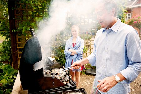 Daughter watching father cook sea food on barbecue Photographie de stock - Premium Libres de Droits, Code: 614-08270463