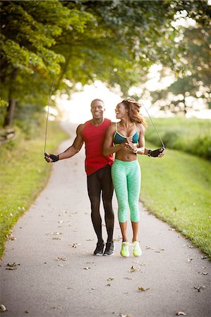 fitness couple outdoors - Young couple training on path skipping in unity Stock Photo - Premium Royalty-Free, Code: 614-08270508