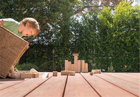 Young boy tipping wooden building blocks out on garden decking Stockbilder - Premium RF Lizenzfrei, Bildnummer: 614-08307567