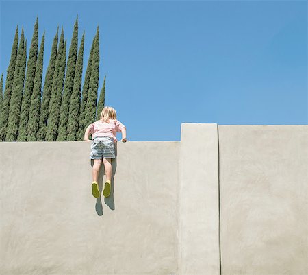 simsearch:614-08487786,k - Young boy looking over tall wall, feet dangling, rear view Stock Photo - Premium Royalty-Free, Code: 614-08307608