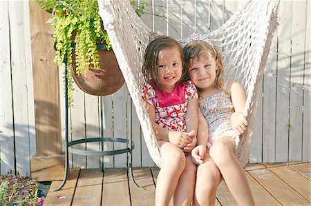 Girls sitting in hammock on porch Foto de stock - Sin royalties Premium, Código: 614-08307645