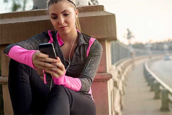 Jogger using cellular phone on bridge, Arroyo Seco Park, Pasadena, California, USA Stock Photo - Premium Royalty-Free, Image code: 614-08307681