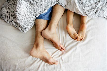 foot of the bed - Bare feet and legs of father and young son lying in bed Stock Photo - Premium Royalty-Free, Code: 614-08307738
