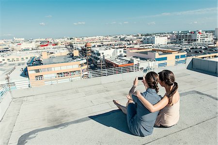 Businesswomen taking selfie with smartphone on roof terrace, Los Angeles, California, USA Stock Photo - Premium Royalty-Free, Code: 614-08307786