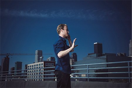 smartphone city night - Businessman speaking on smartphone on roof terrace, Los Angeles, California, USA Stock Photo - Premium Royalty-Free, Code: 614-08307794