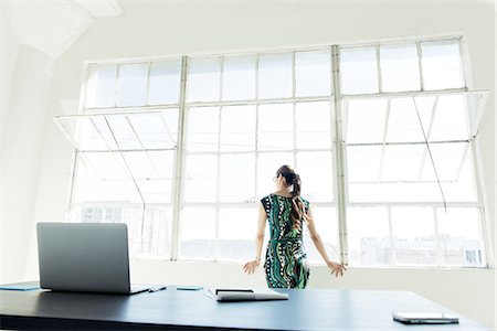 Businesswoman looking out of office window Stock Photo - Premium Royalty-Free, Code: 614-08307808