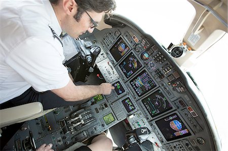 simsearch:614-08307862,k - Male pilot preparing cockpit of private jet Foto de stock - Sin royalties Premium, Código: 614-08307843