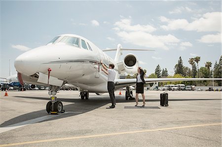 Female businesswoman preparing to  travel in private jet at airport Fotografie stock - Premium Royalty-Free, Codice: 614-08307856