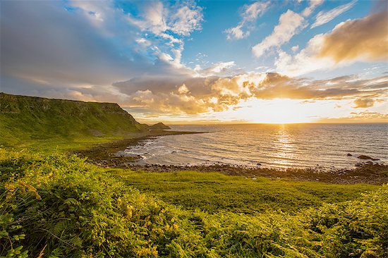 Sun setting on horizon over ocean, Giants Causeway, Bushmills, County Antrim, Ireland, UK Stock Photo - Premium Royalty-Free, Image code: 614-08307899