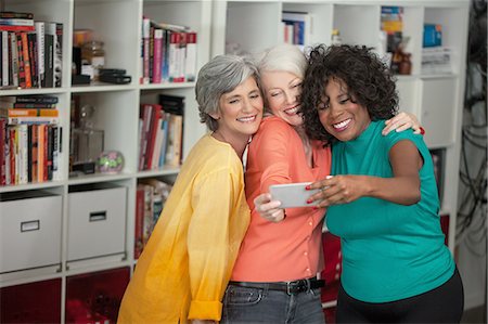 peach color - Portrait of three mature women, taking self portrait, using smartphone Stock Photo - Premium Royalty-Free, Code: 614-08307924