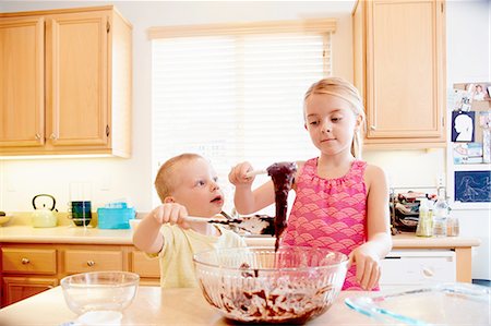 Siblings melting chocolate in mixing bowl Stock Photo - Premium Royalty-Free, Code: 614-08307983