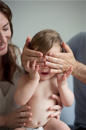 play with baby - Mother and father playing peek a boo with baby boy Stock Photo - Premium Royalty-Free, Code: 614-08308009