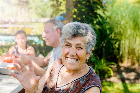 signes vitaux - Senior woman outdoors with family looking at camera waving, smiling Photographie de stock - Premium Libres de Droits, Code: 614-08308016