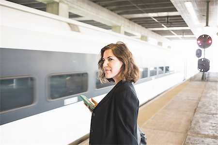 embarquement - Mid adult woman waiting to board train, holding smartphone Photographie de stock - Premium Libres de Droits, Code: 614-08329204