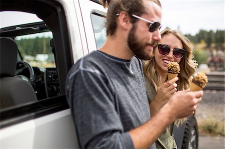 sorvete de casquinha - Young couple leaning against jeep eating ice cream cones Foto de stock - Royalty Free Premium, Número: 614-08329409