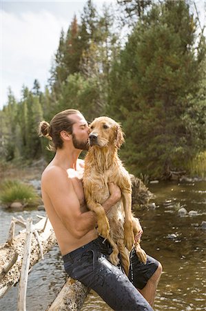 Young man kissing his wet dog at river, Lake Tahoe, Nevada, USA Stock Photo - Premium Royalty-Free, Code: 614-08329425