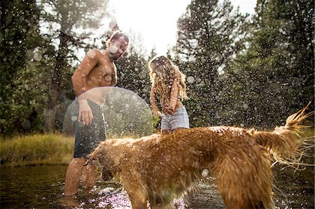 paz y tranquilidad - Dog splashing young couple in river, Lake Tahoe, Nevada, USA Foto de stock - Sin royalties Premium, Código: 614-08329434