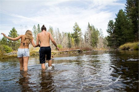 Rear view of young couple crossing river, Lake Tahoe, Nevada, USA Stock Photo - Premium Royalty-Free, Code: 614-08329438