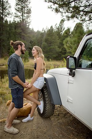 Young couple holding hands next to jeep on riverside, Lake Tahoe, Nevada, USA Foto de stock - Sin royalties Premium, Código: 614-08329454