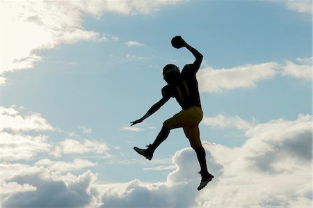 simsearch:614-00893424,k - Teenage american football player, jumping with ball, mid air Stock Photo - Premium Royalty-Free, Code: 614-08329463