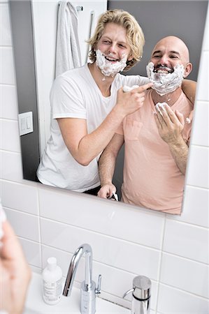 simsearch:649-08179955,k - Bathroom mirror image of male couple having fun shaving Fotografie stock - Premium Royalty-Free, Codice: 614-08329485